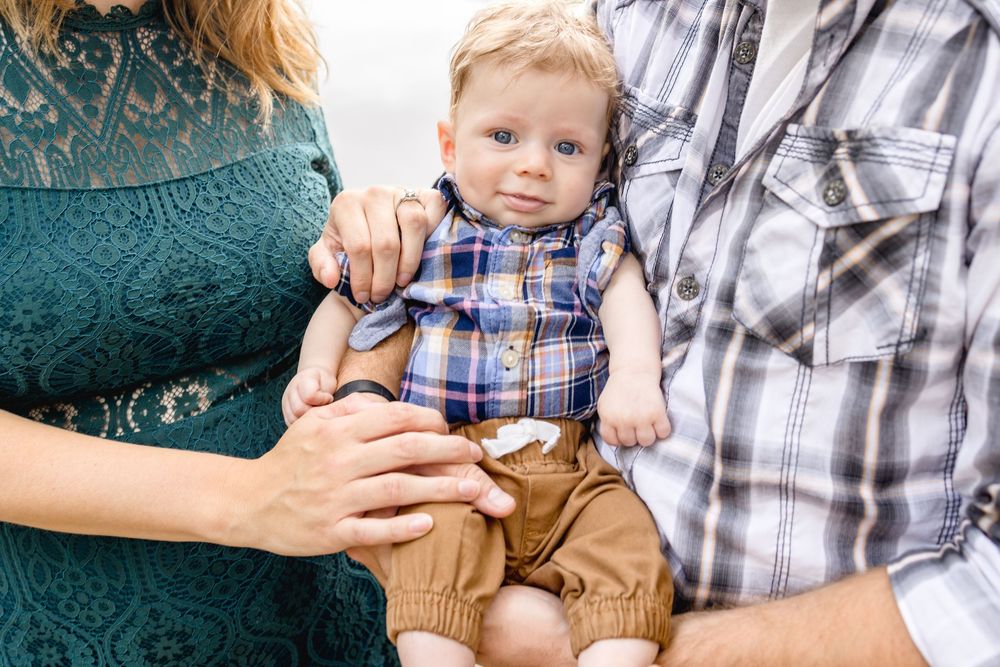 Sweet candid moments with a baby wearing plaid and khakis during a photo session.