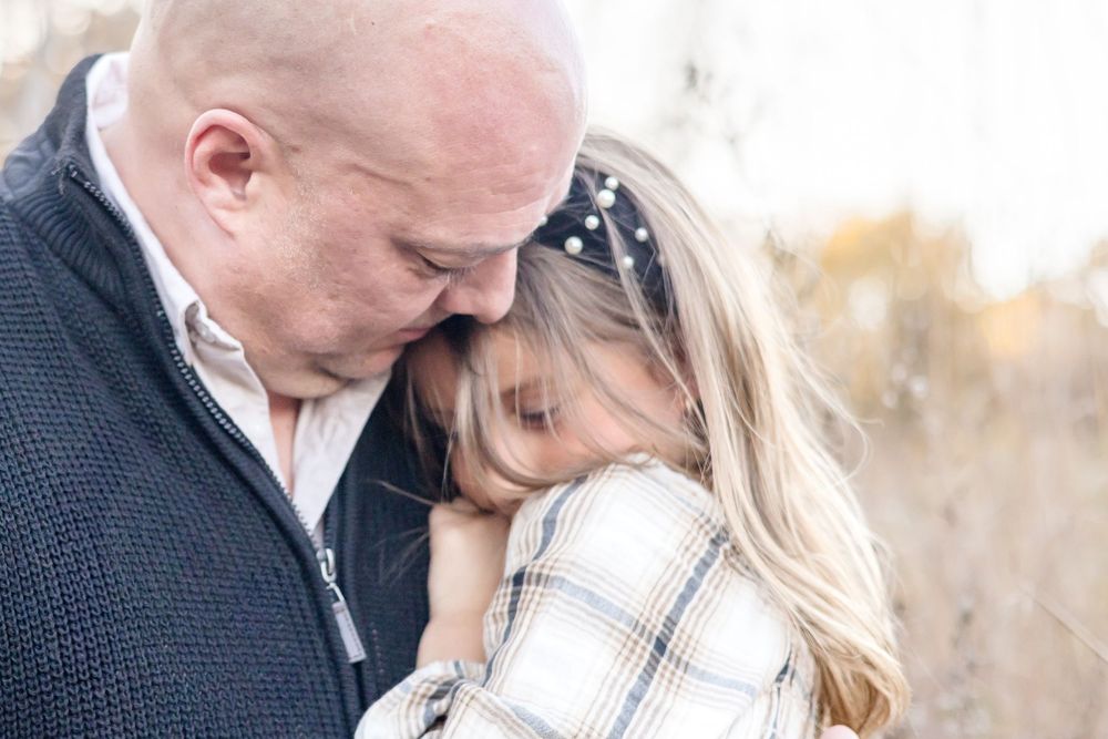 An intimate moment between a couple during their outdoor photoshoot in winter scenery.