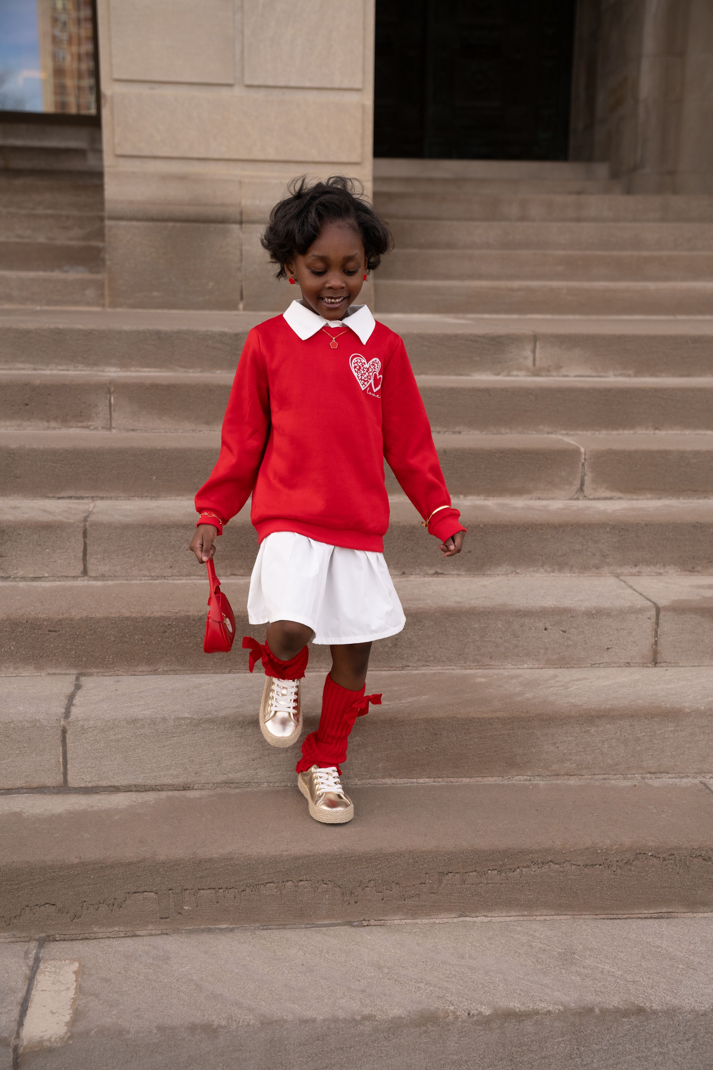A person in a red sweater and white skirt descends concrete steps in three sequential photos.