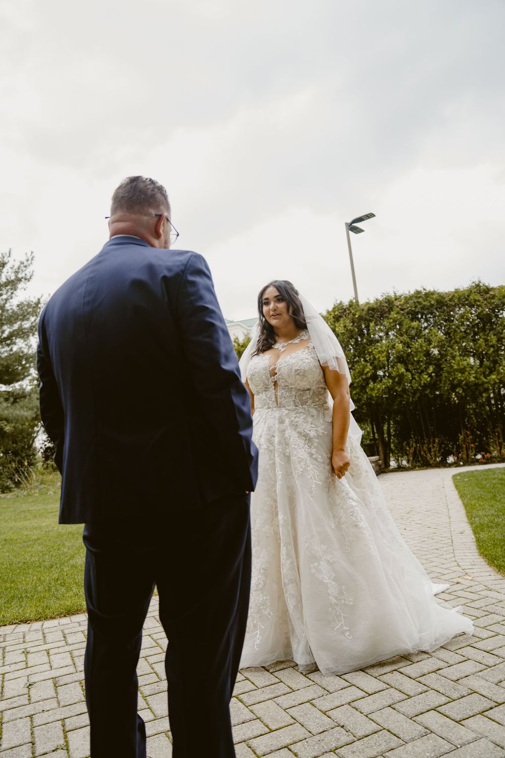 Wedding couple having first look moment on stone pathway.