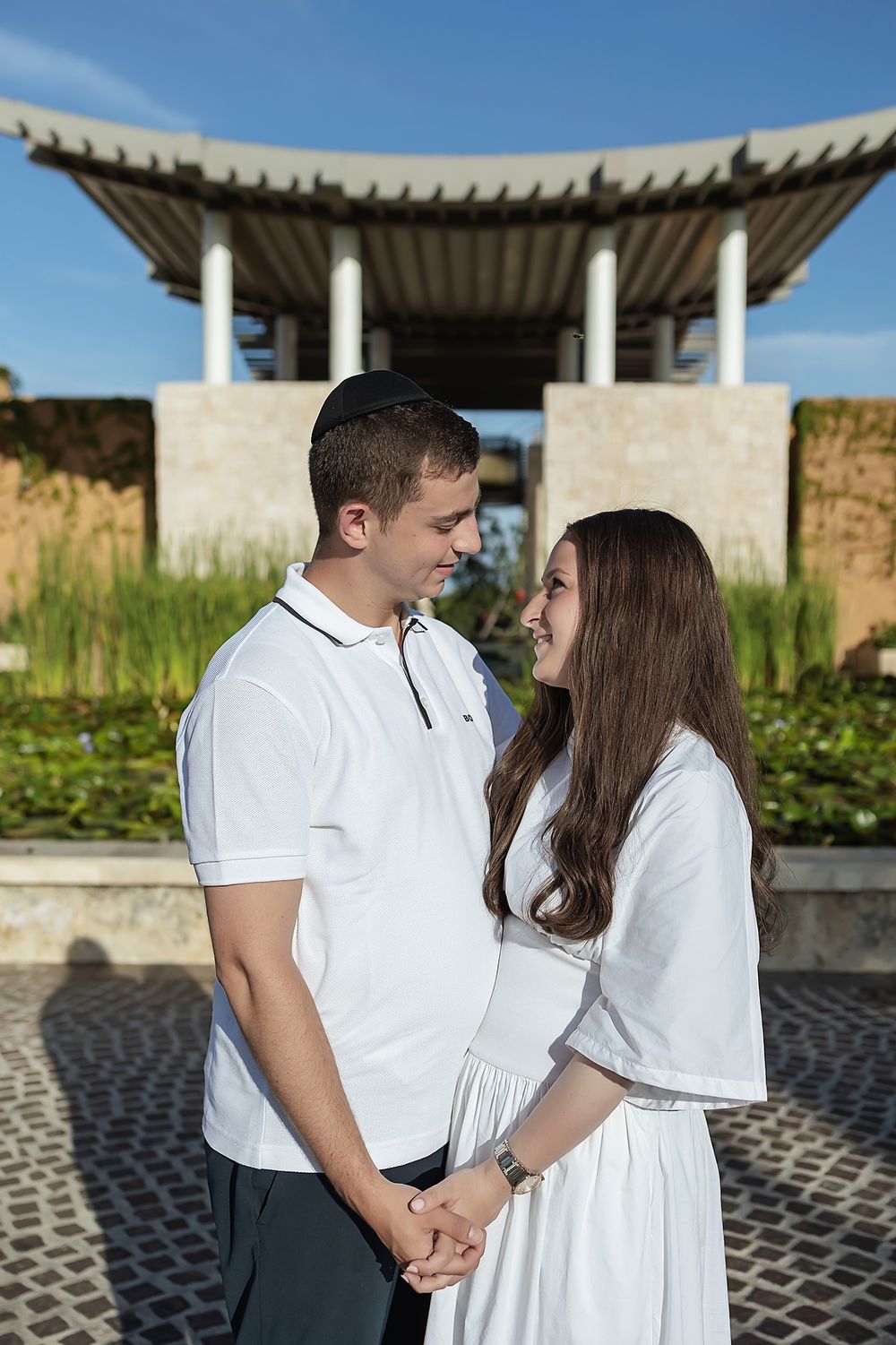 Couple holding hands in front of Banyan Tree Mayakoba architecture.