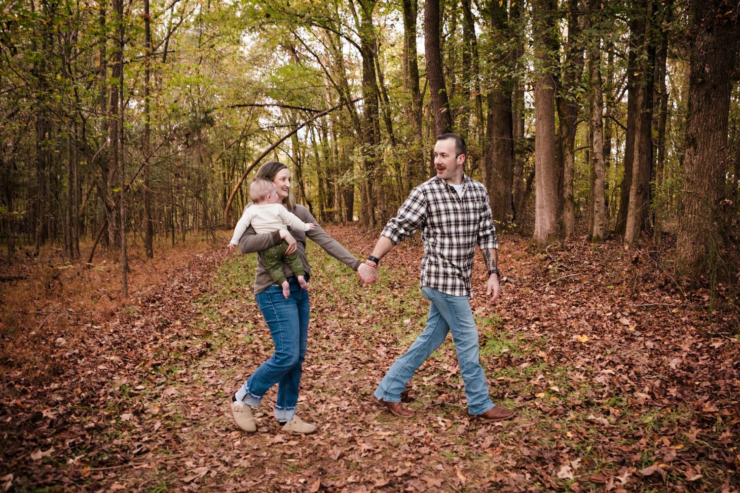 Family Session. Mom and Dad walking with they new baby.