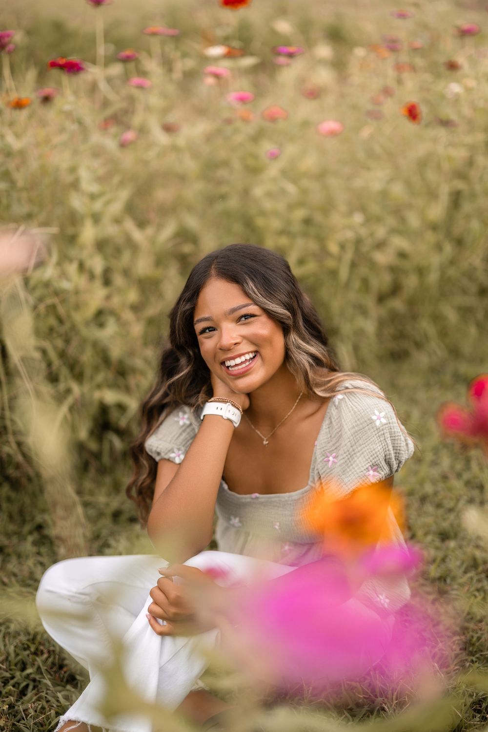 A joyful photoshoot in a wildflower field with pink and orange blooms on a sunny day.