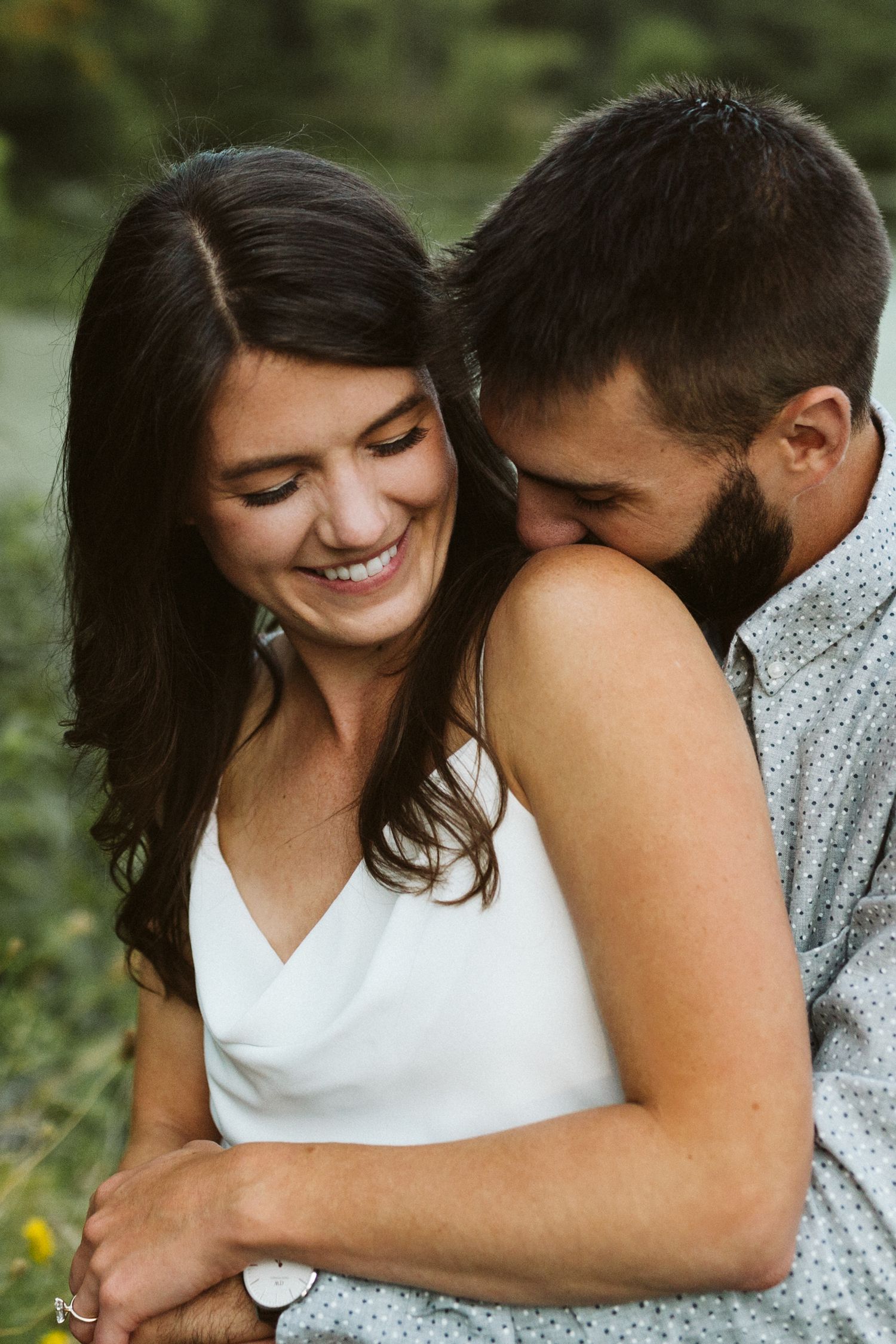 A joyful candid moment shared between two people in a natural outdoor setting.