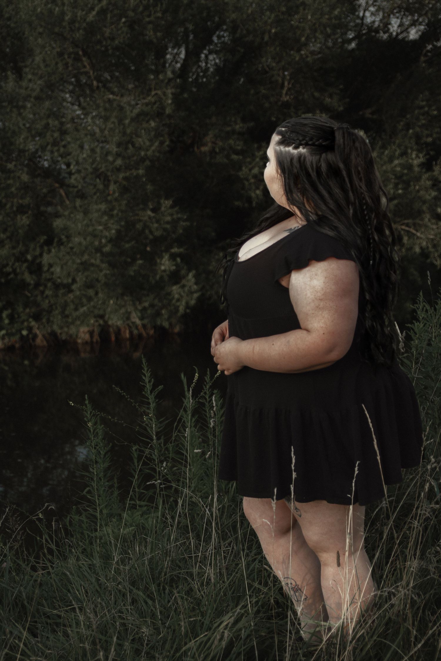 Artistic outdoor portrait session featuring natural elements and dark tones.