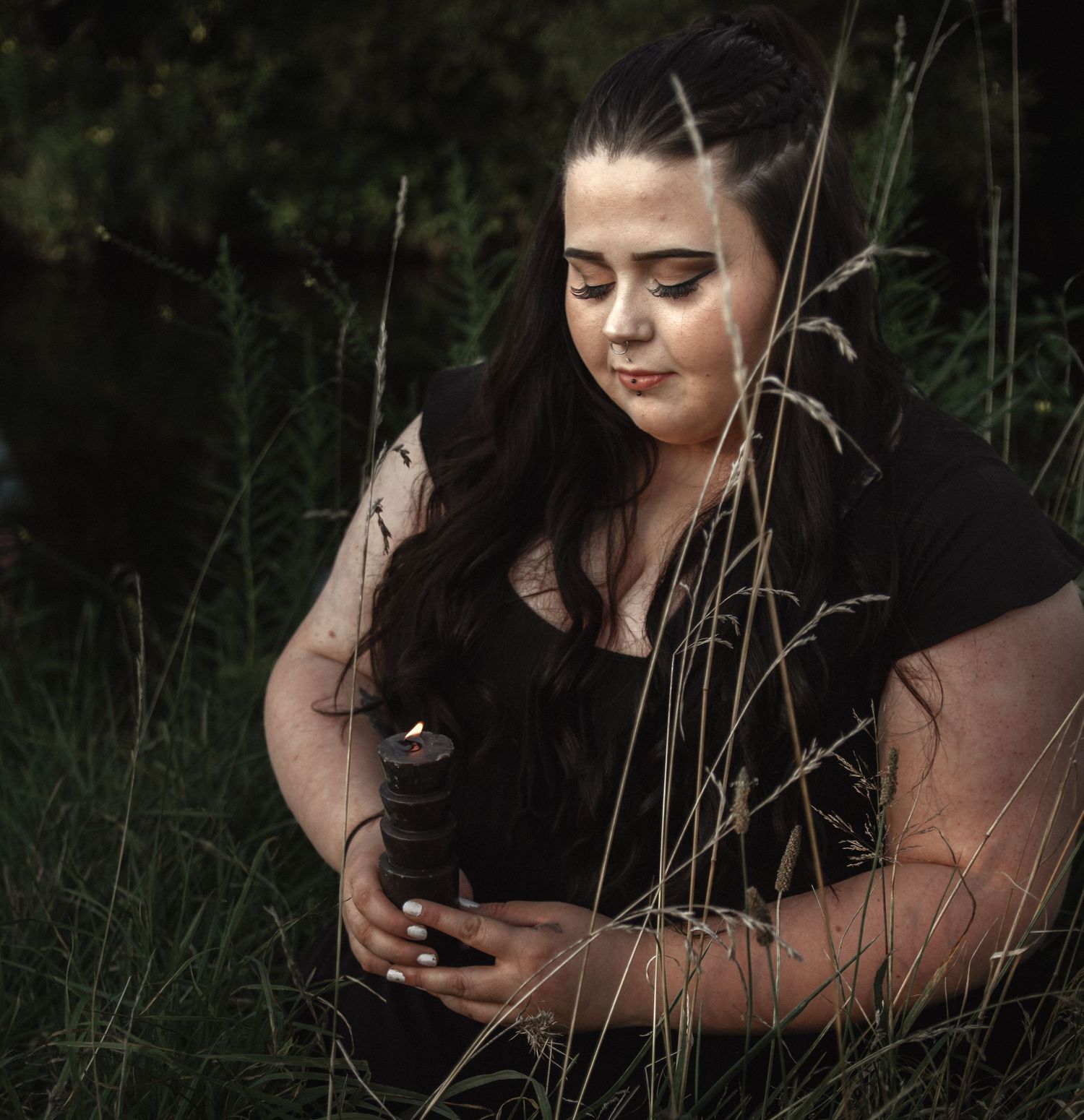 Moody outdoor photography session with natural grass elements and soft lighting.