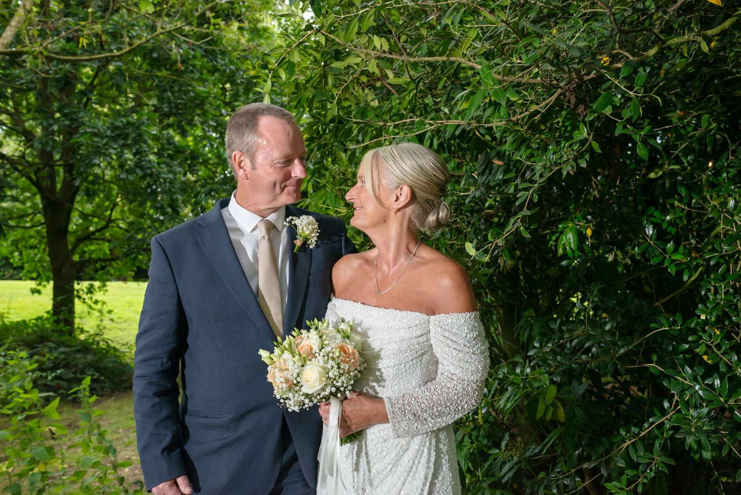 Cheshire Wedding photographer Michael Pardoe captures newly married couple portrait with bouquet in the gardens of DeVere Cranage Estate.