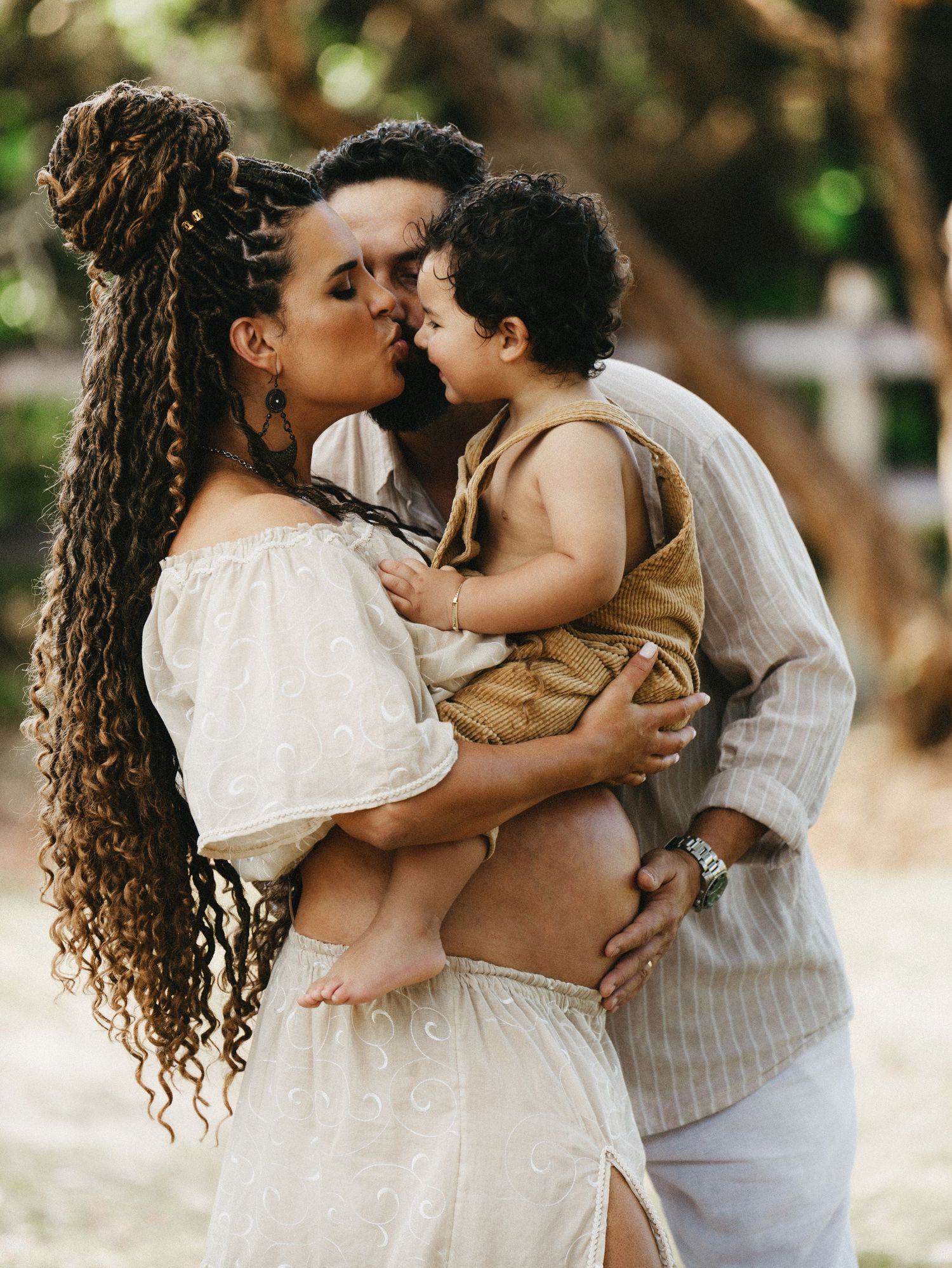 An intimate family moment captured outdoors with soft natural lighting.