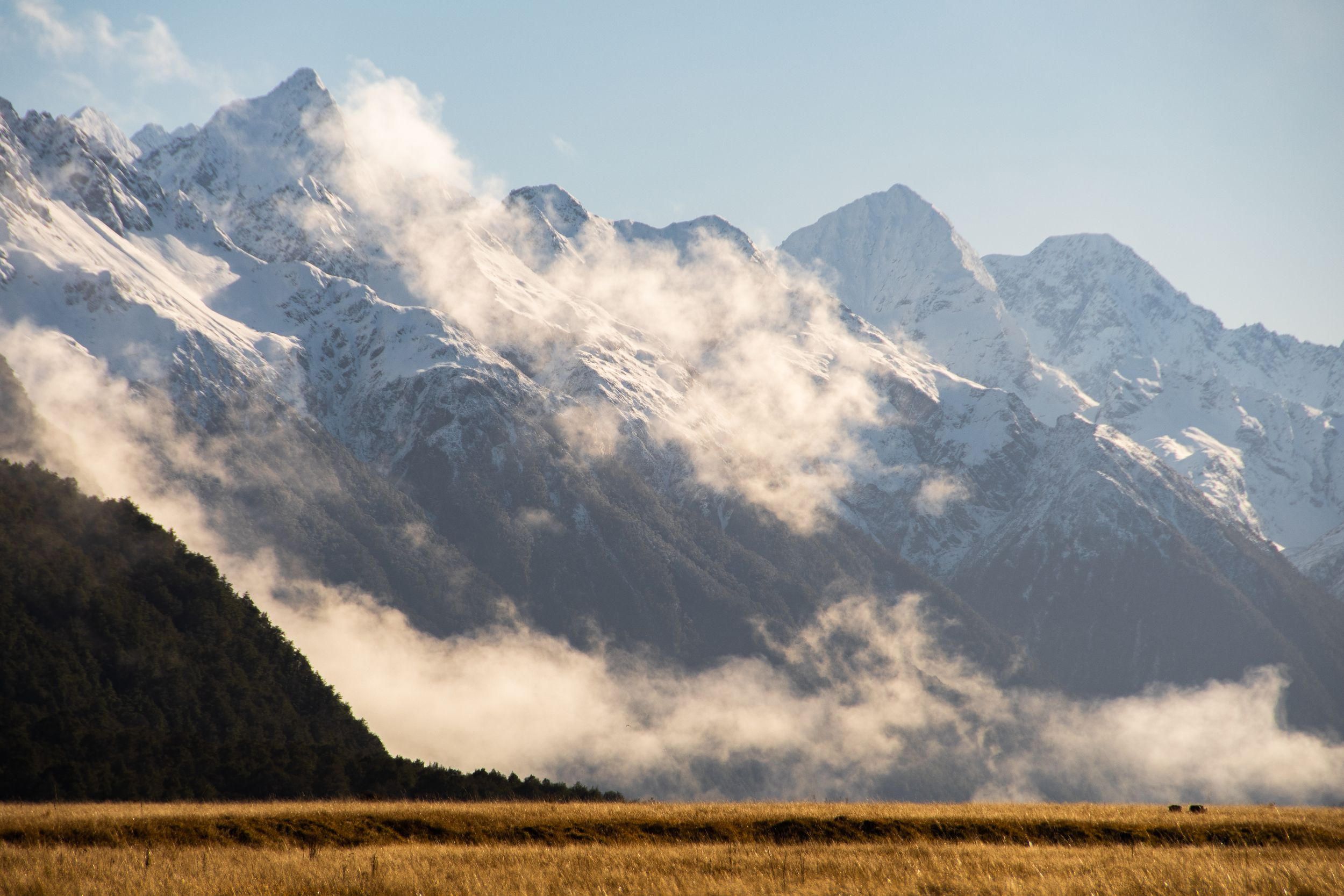 Chaine de montagnes enneigées et nuages matinaux dans le parc national du Fjordland, Nouvelle-Zélande