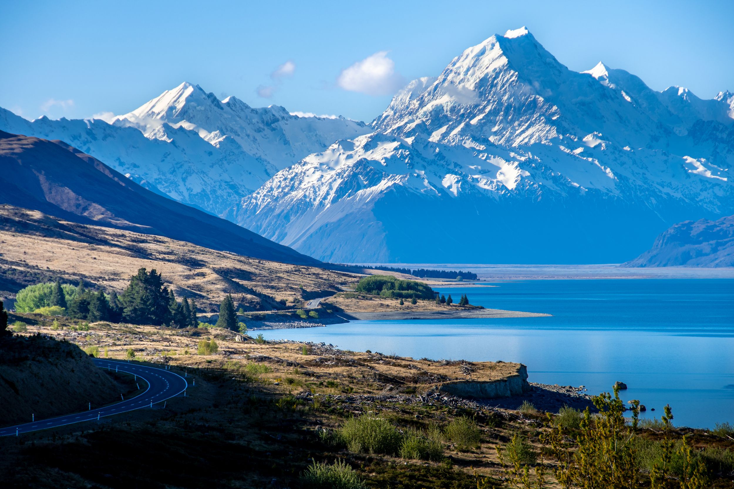 Route panoramique au bord du lac Pukaki avec vue sur le Mont Cook enneigé