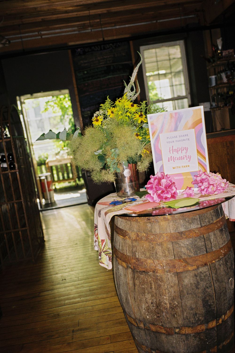 The welcome table and entryway in a wine bar announcing a couples engagement during a celebration in the summer in Brunswick, Maine.