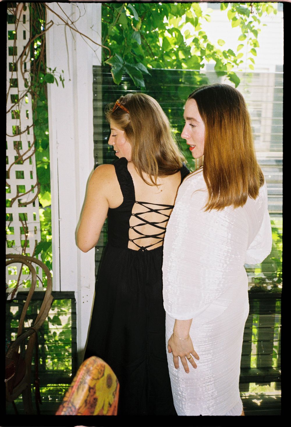The bride to be and her friend pose with each other lovingly on 35mm film at an engagement party in the summer in Maine.