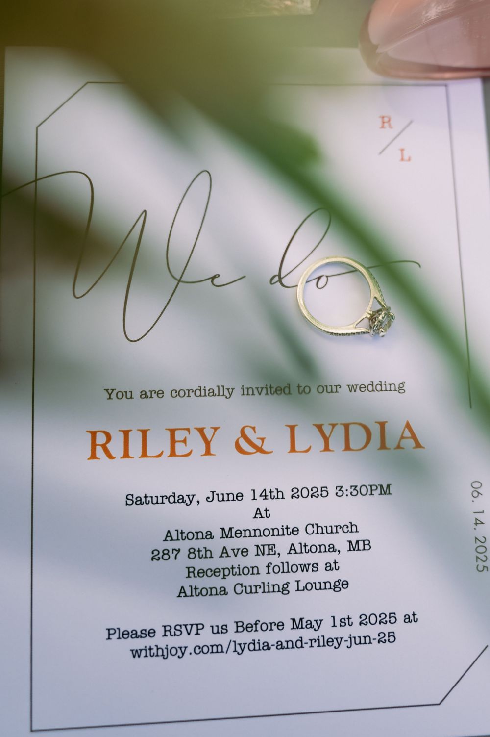 Wedding invitation with engagement ring showing details for Riley and Lydia's ceremony.
