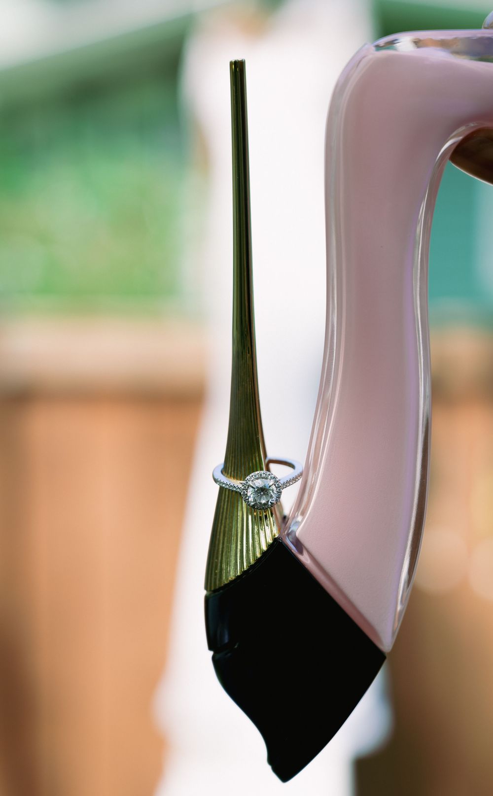 Close-up sequence of a wedding ring being placed on a white satin surface against a green background.