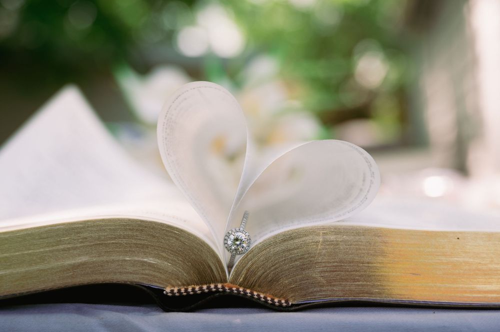 An open book with blurred pages resting on a white surface in natural light.