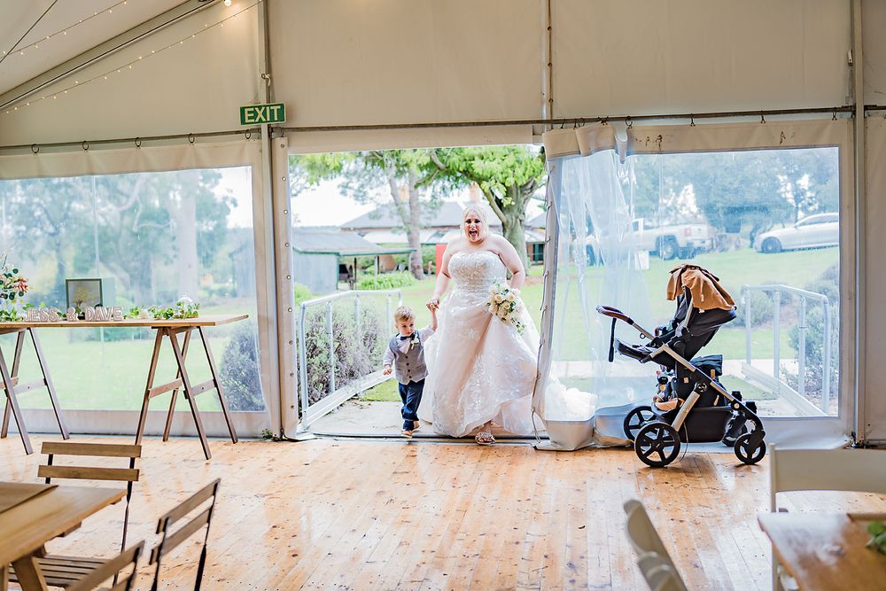 Event tent interior with empty chairs and a baby stroller near the entrance.