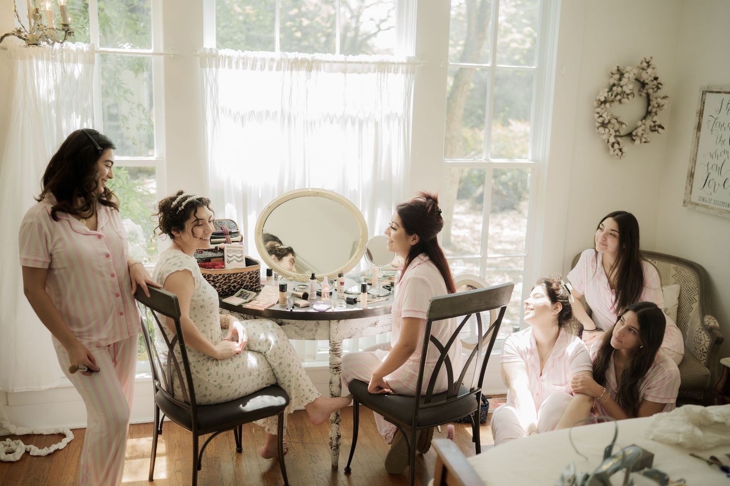 Wedding preparation scene in bright room with natural light streaming through windows.
