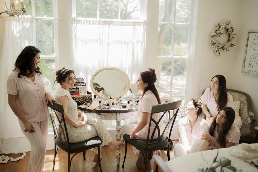 Wedding preparation scene in bright room with natural light streaming through windows.