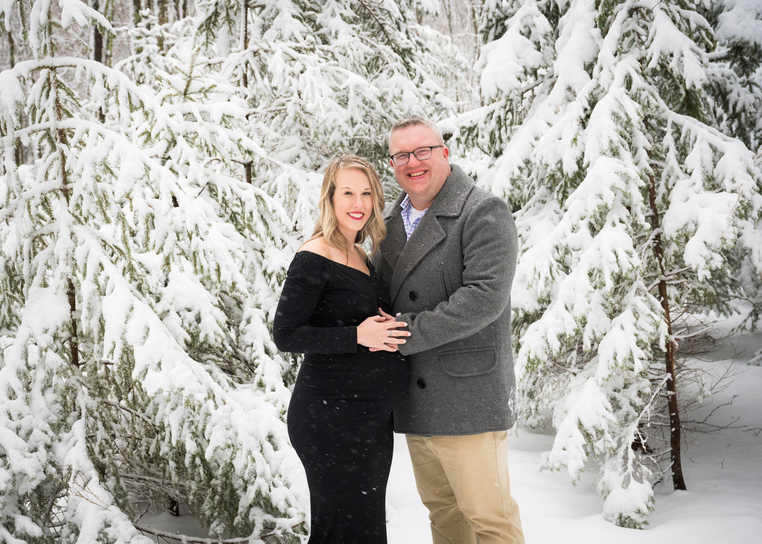 A couple embraces in a romantic winter scene surrounded by snow-covered evergreen trees in five sequential photos.