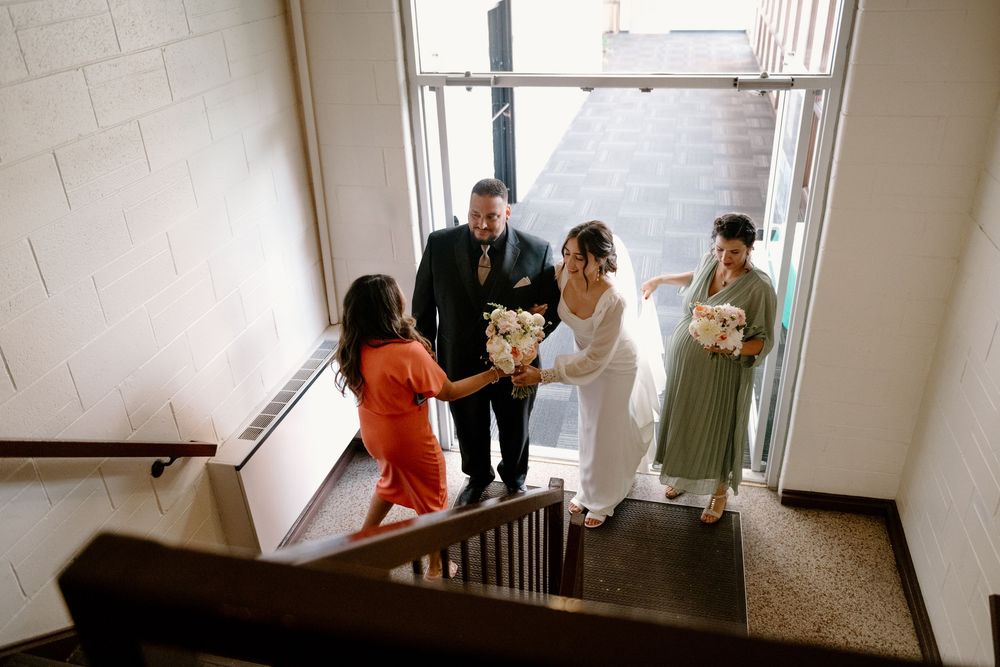 Office workers having a conversation while standing in a bright modern corridor with windows.