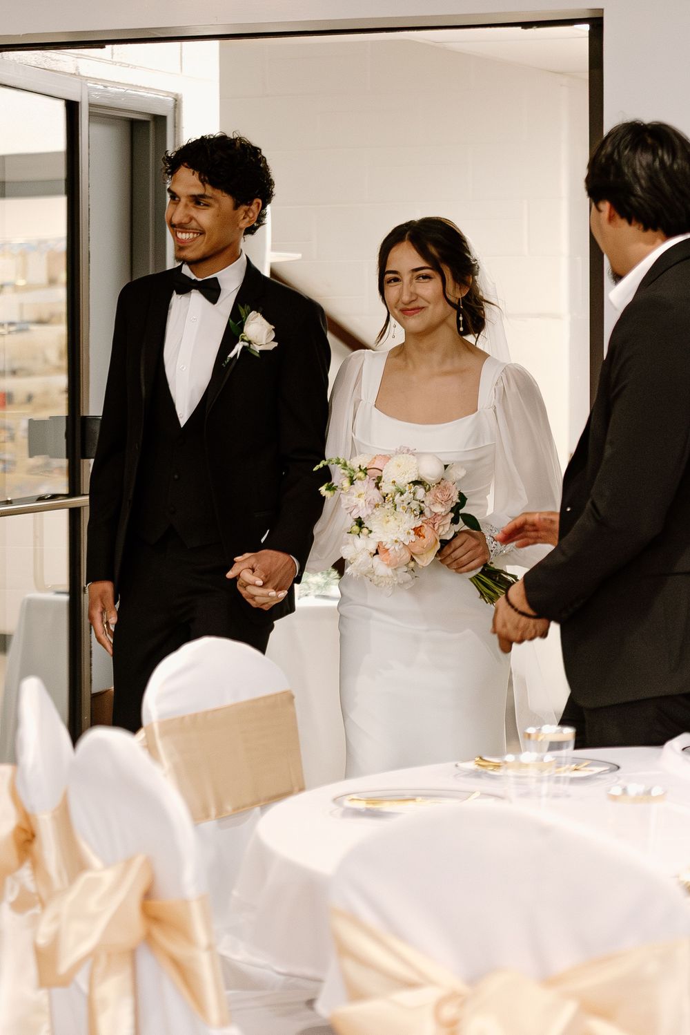 A wedding ceremony montage showing the bride and groom at a bright, modern indoor venue with white decorations.