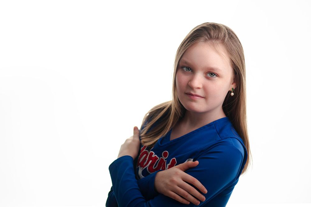 Young female cheerleader posing on a white backdrop.