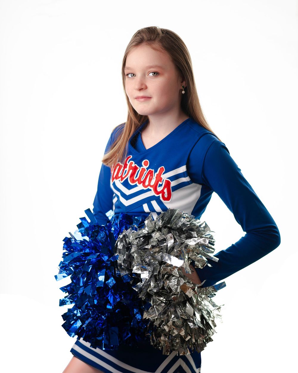 Young female cheerleader posing on a white backdrop.