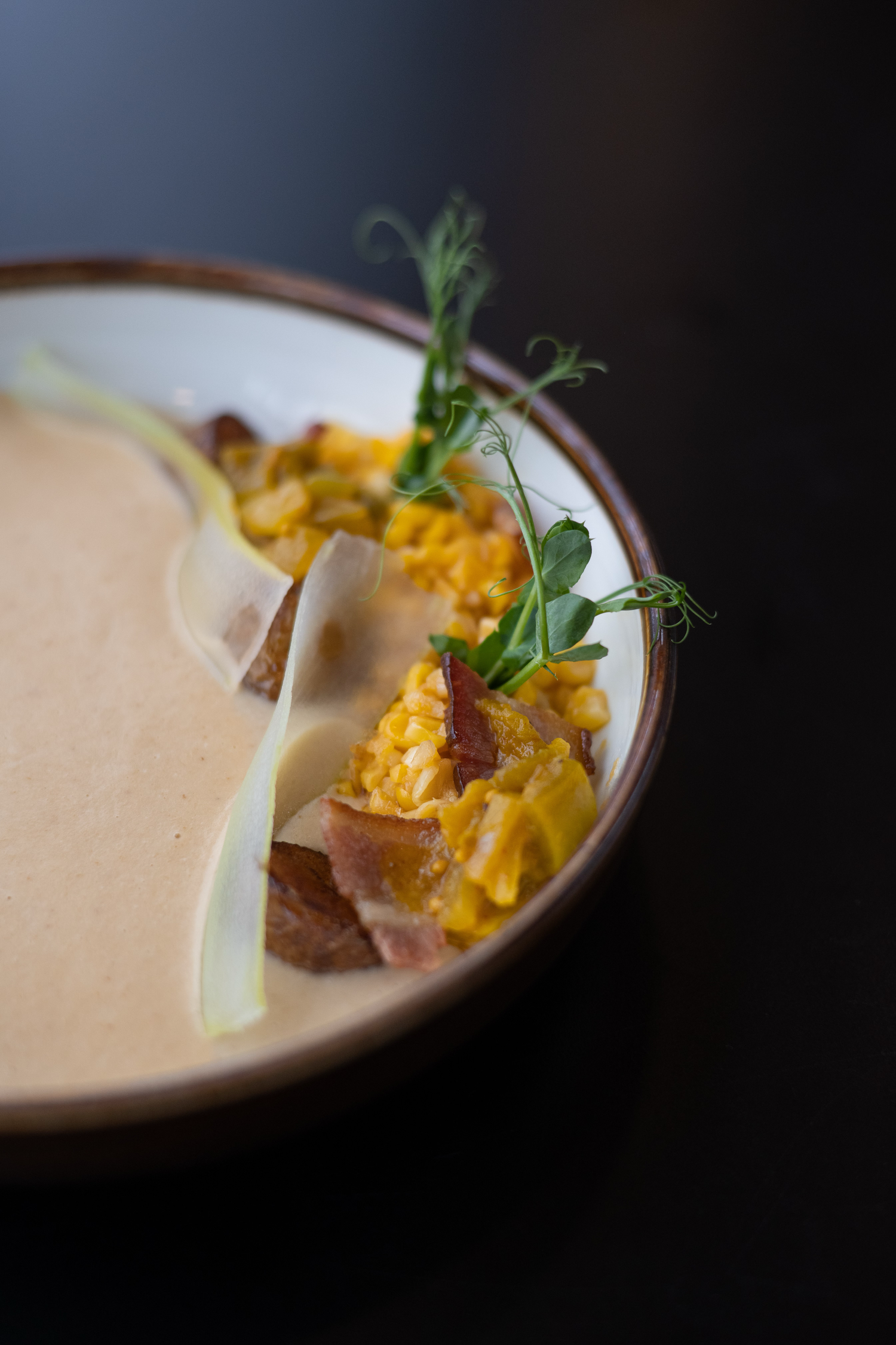 Close-up of an elegant plated dish with scrambled eggs and fresh herbs on a ceramic plate.