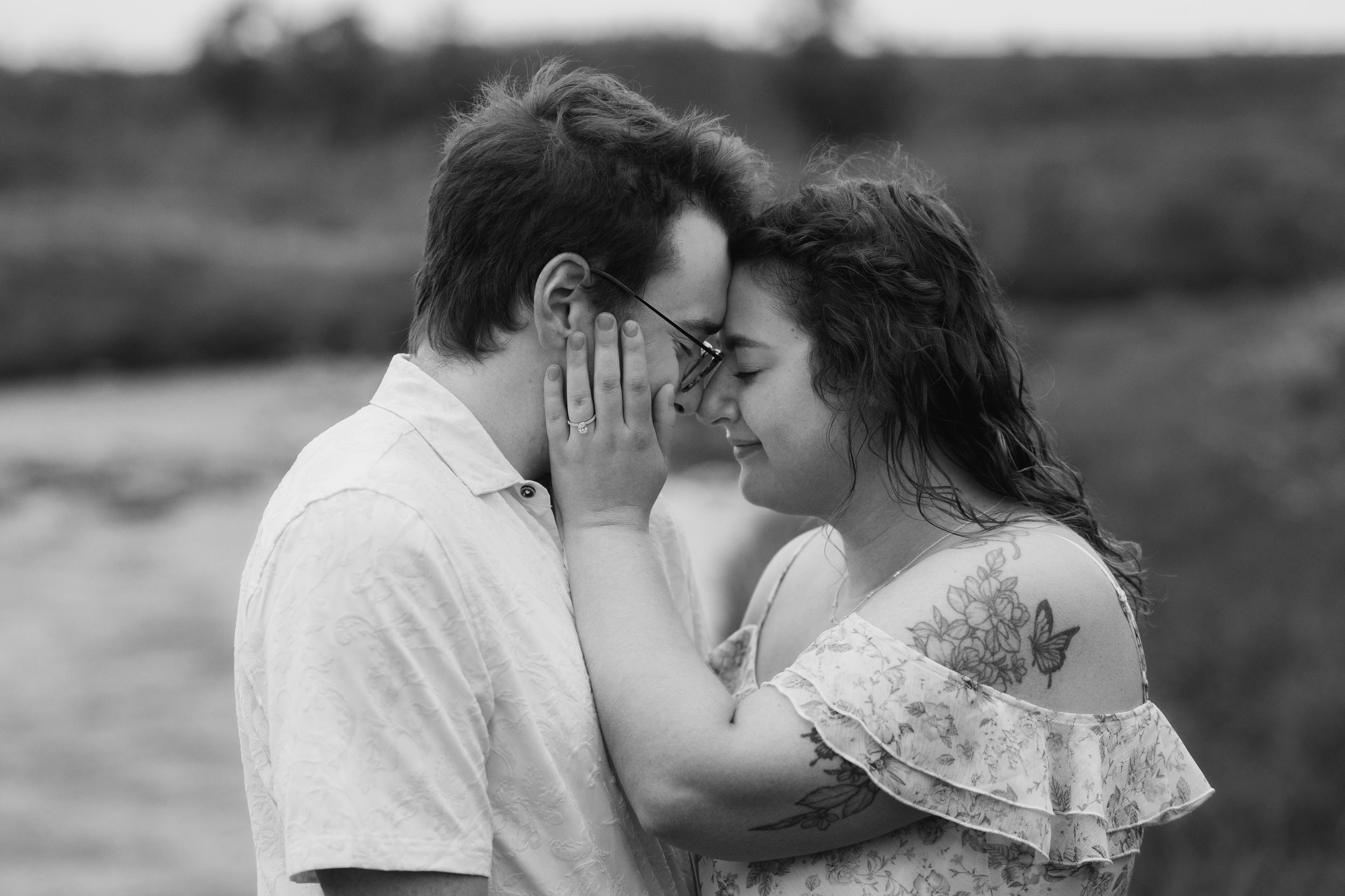 A romantic black and white photo series showing a couple kissing in different poses outdoors.
