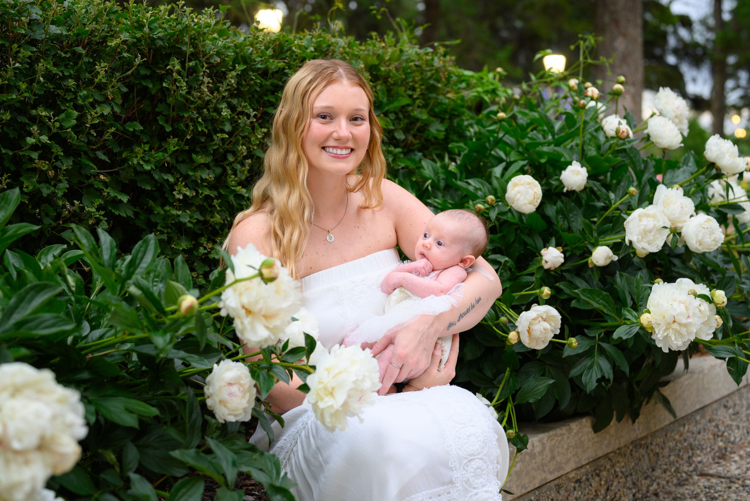 A white floral garden setting with blooming peonies creates a serene outdoor backdrop.