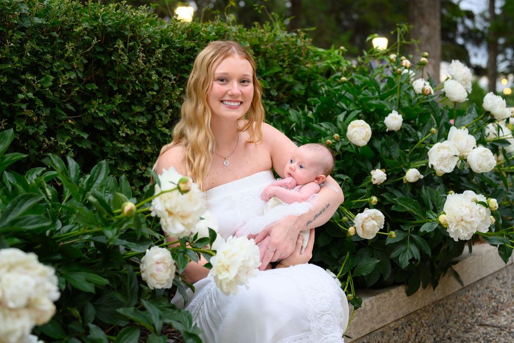 A white floral garden setting with blooming peonies creates a serene outdoor backdrop.