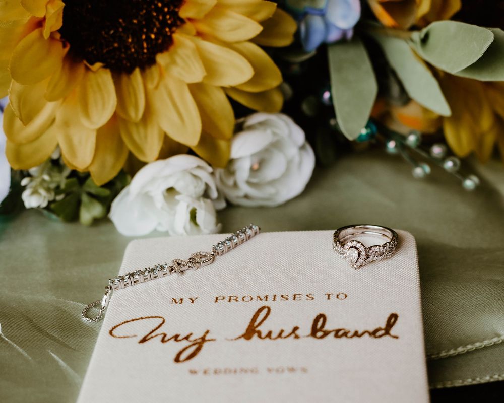 Handwritten wedding vows card displayed with yellow sunflowers and delicate details.