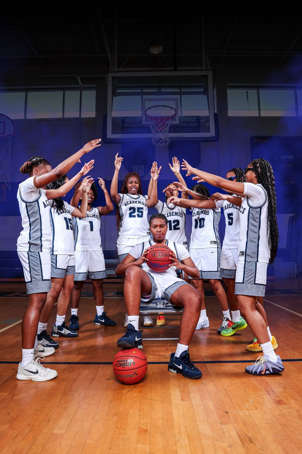Basketball team poses for creative panoramic photo sequence on hardwood court showing progressive movement.