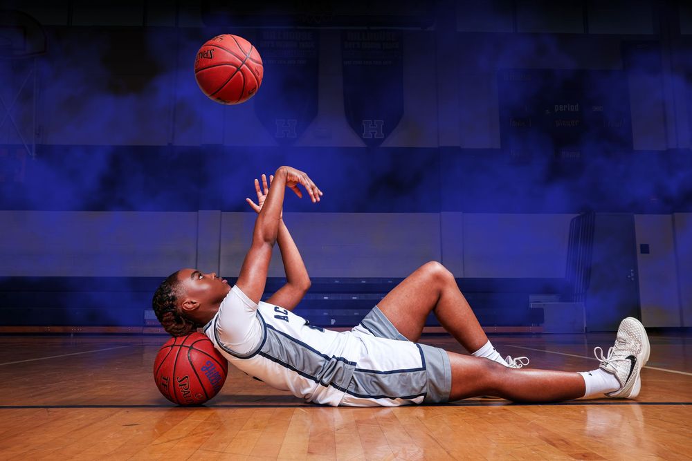 A sequence of photos showing a basketball player falling down on a blue court during a game.
