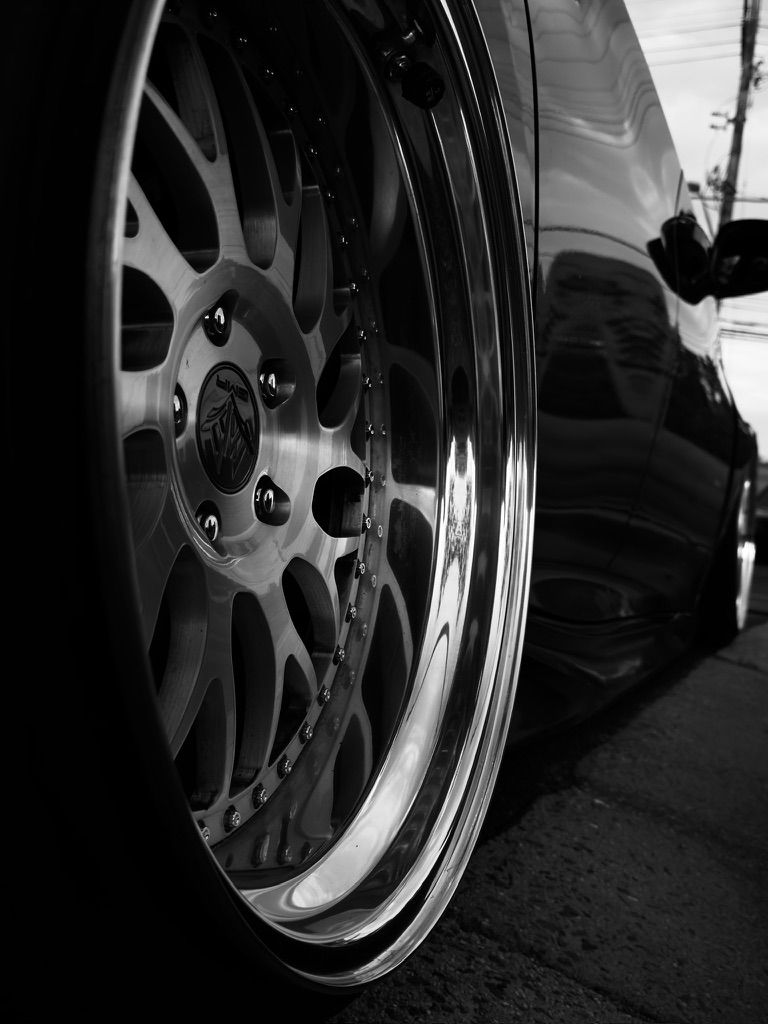 Close-up black and white shot of a polished multi-spoke aftermarket alloy wheel.