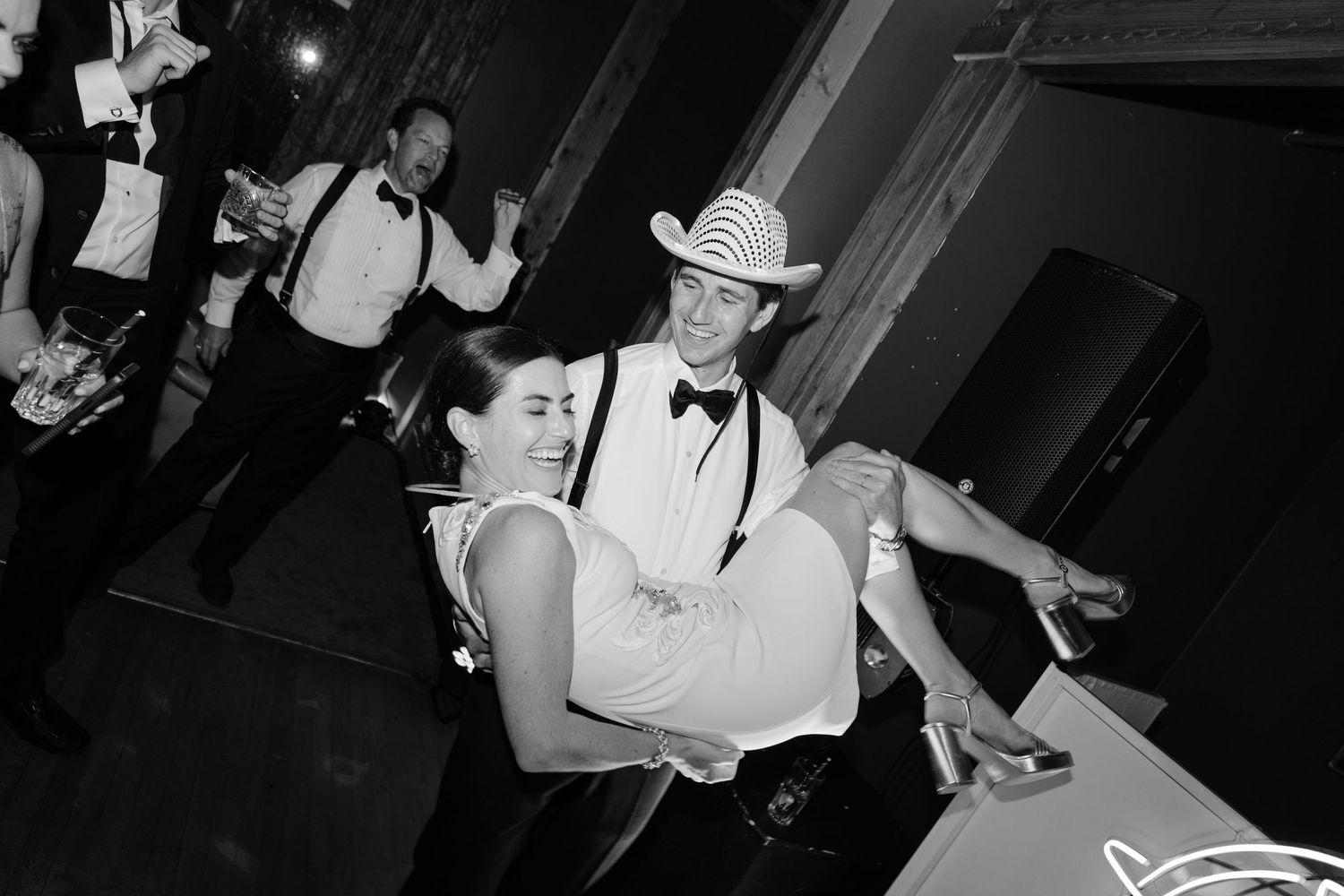 Wedding reception dancers in black and white with person wearing cowboy hat.