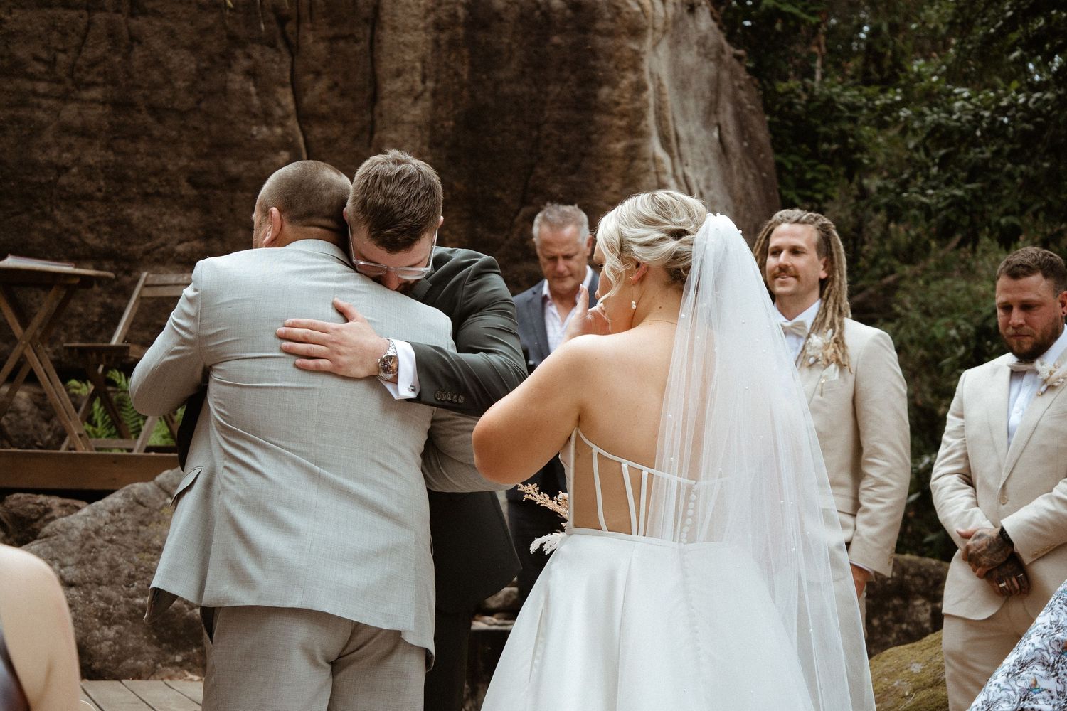Emotional moment shared during outdoor wedding ceremony surrounded by loved ones.