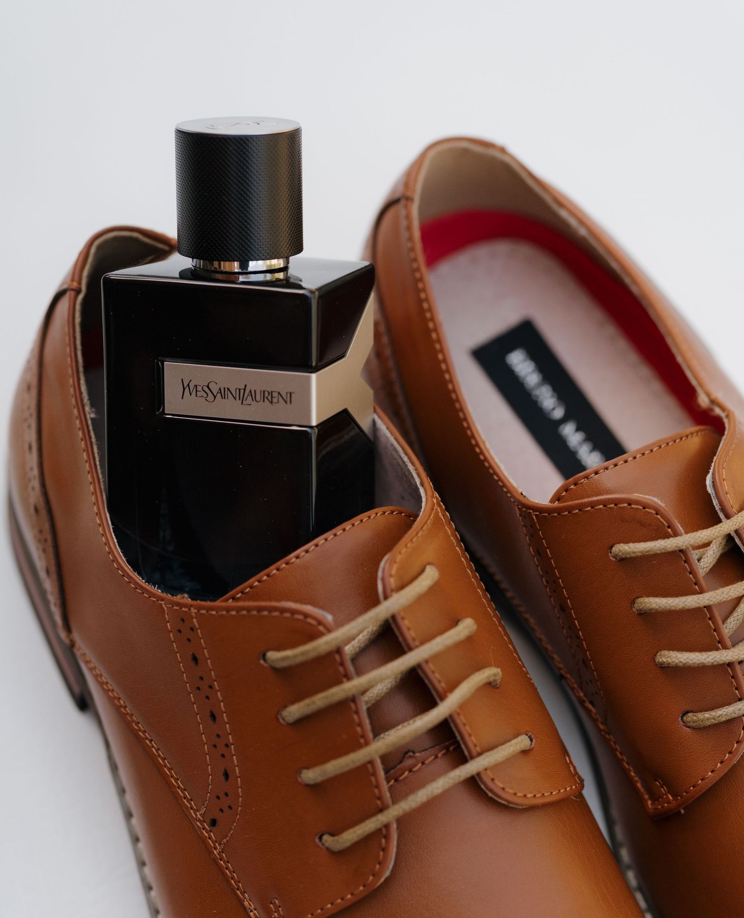 Brown leather oxford dress shoes with tan laces shown from different angles against white background.
