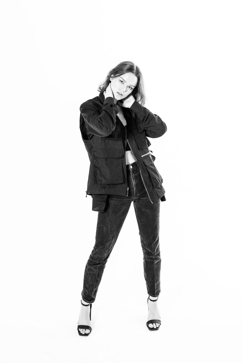 Black and white fashion portrait in casual all-black outfit with sandals.