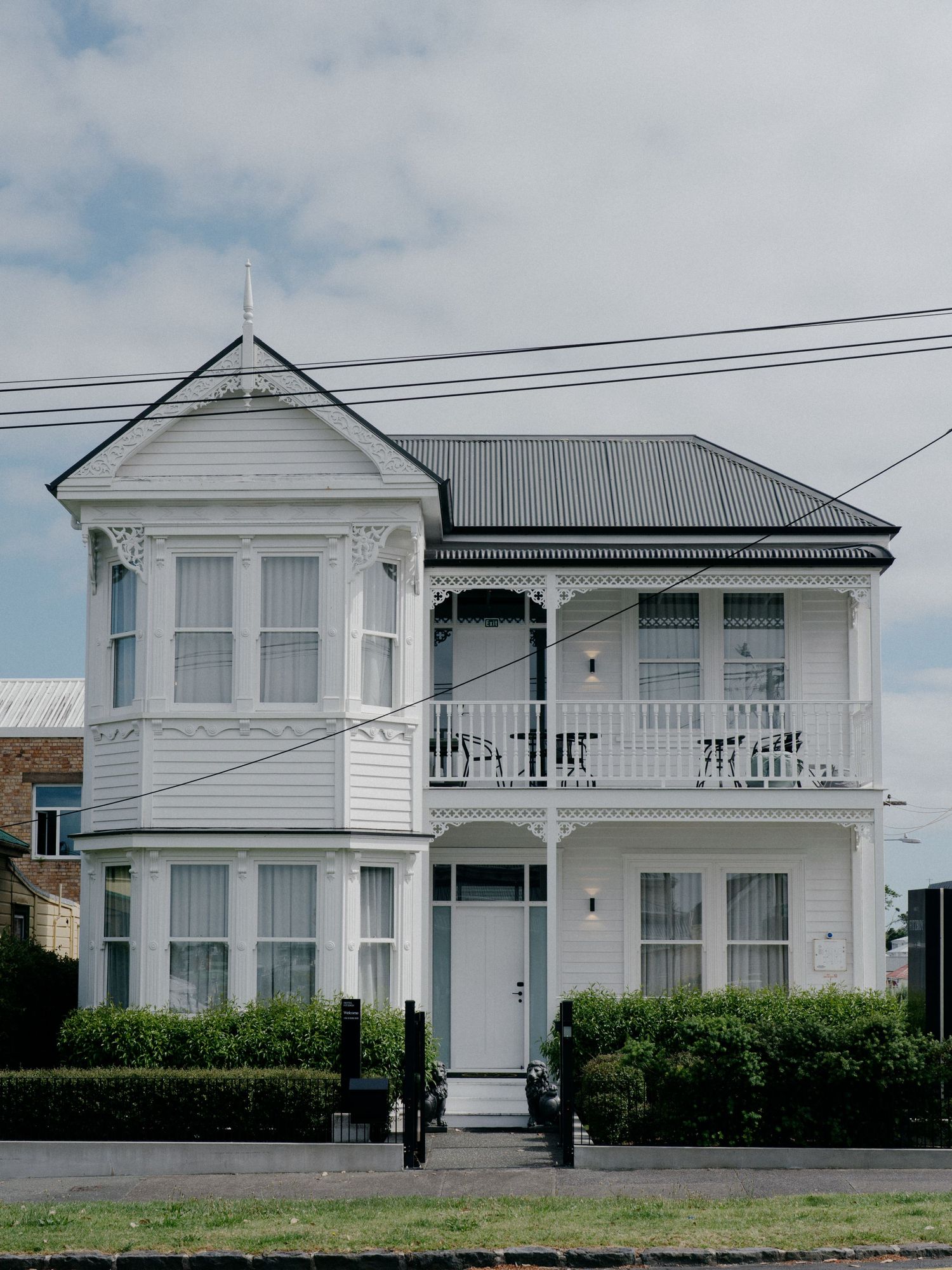 Classic white Victorian two-story house with bay windows and ornate trim details.