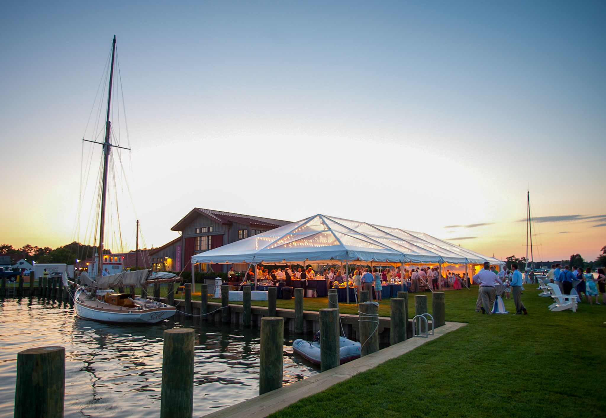 Waterfront wedding reception tent setup at sunset with boats docked nearby | Tom McCall Photography | Eastern Shore Maryland | MESW