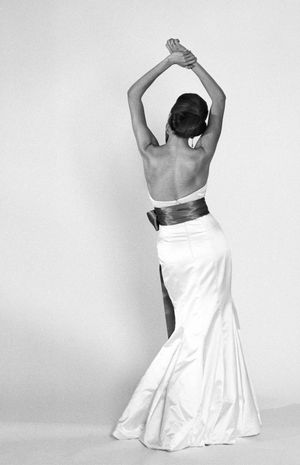 Black and white photo series showing graceful dance poses in a flowing white dress against a plain background.