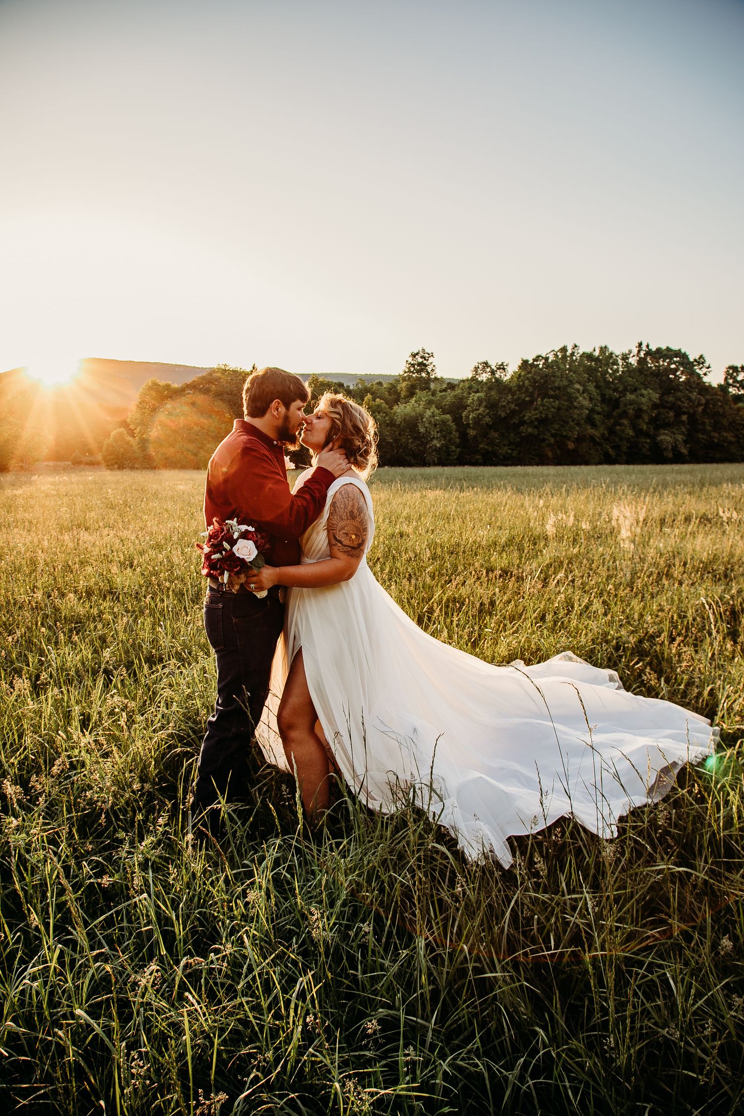 Romantic sunset portrait of couple in field with flowing white wedding dress. King, NC