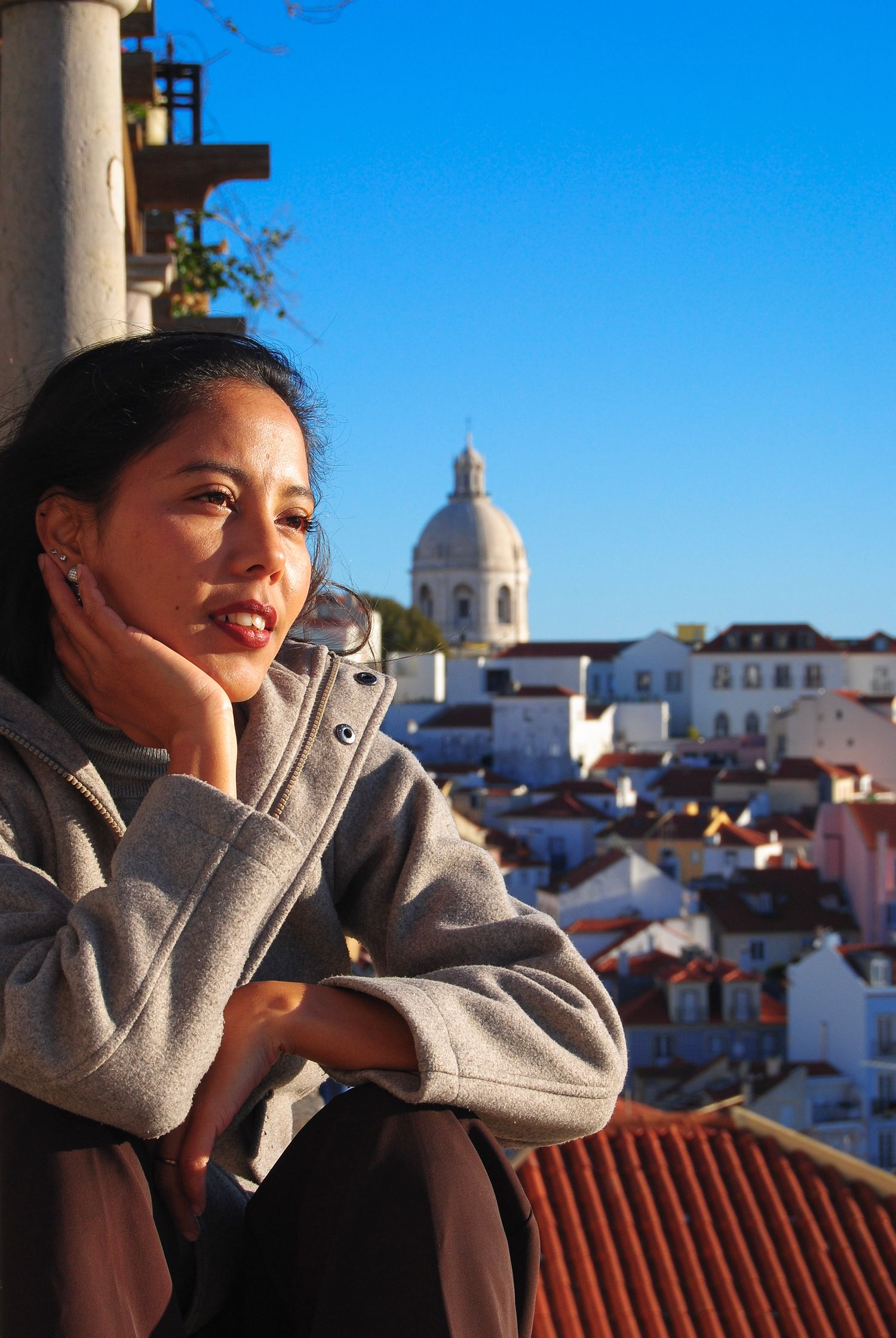 Woman sitting on viewpoint bench in Lisbon