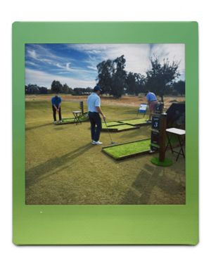 Golfers practicing their putting skills on a sunny day at an outdoor training facility with alignment aids and mats in Fresno, CA.