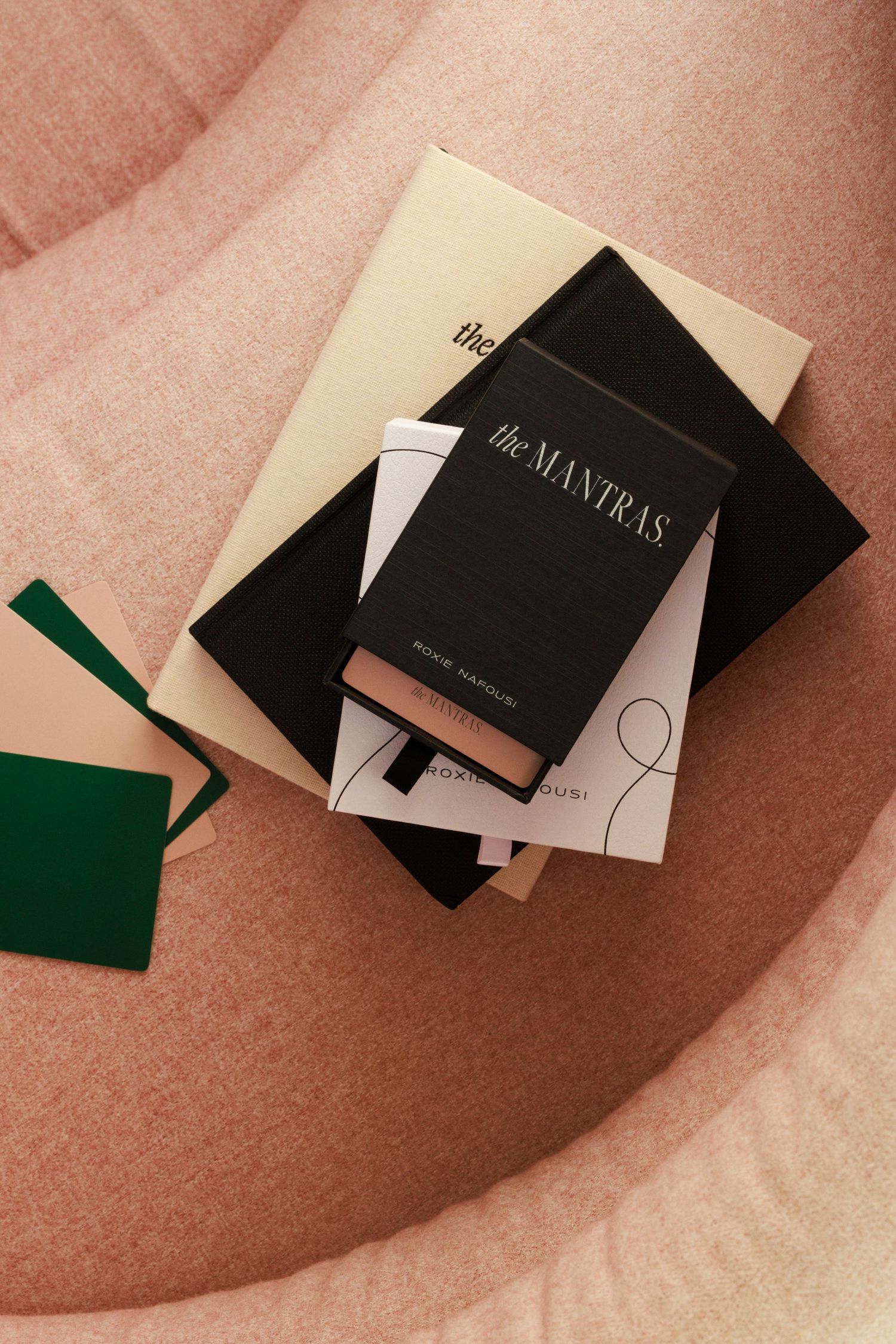 Black and white minimalist notebooks arranged on a pink textured surface.