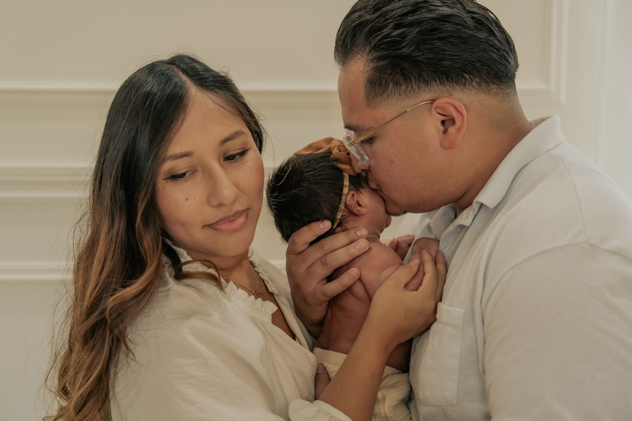 Intimate family moment with new parents cradling their infant.