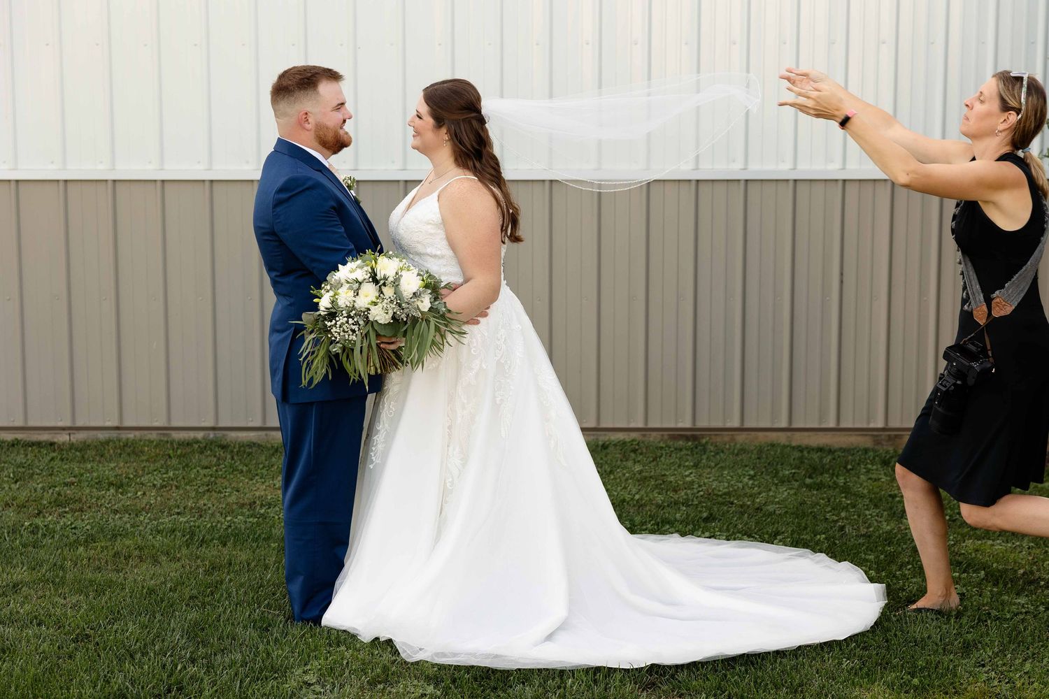 A couple in wedding attire dances together during their first dance at an outdoor reception.