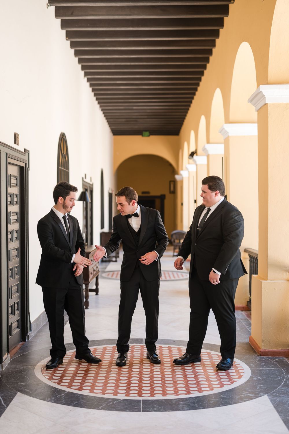 Groom and groomsmen standing together in corridor at Hotel El Convento in Old San Juan