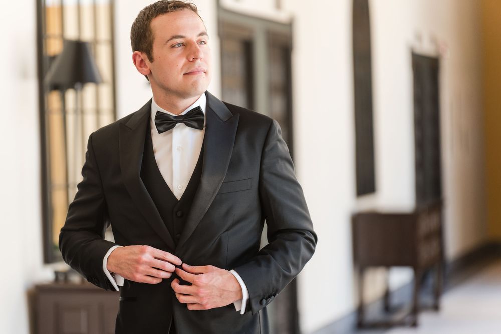 Groom adjusting tuxedo during wedding day at Hotel El Convento Puerto Rico